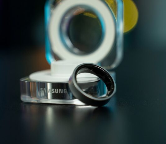 “AI가 만든 건강관리 루틴, 일상에 스며들다” A black samsung ring with its charging dock.