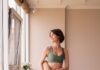“필라테스 열풍, 집에서도 건강하게 즐기는 실생활 루틴” a woman in a green sports bra top and leggings holding a yoga mat