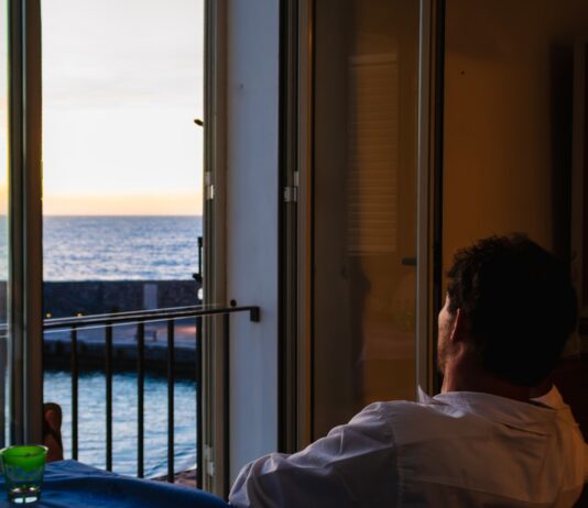 스마트 슬로우 라이프, 정신 건강을 지키는 새로운 흐름 Man looking out window at the ocean sunset